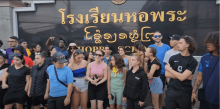Groupe d'élèves des 7 lycées Provence Formation devant un panneau de bienvenue écrit en thaïlandais, en Thaïlande  